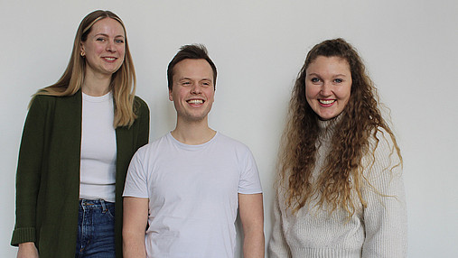 Das Foto zeigt das Gründungsteam von SUMM AI: Vanessa Theel, Nicholas Wolf und Flora Geske (von links).