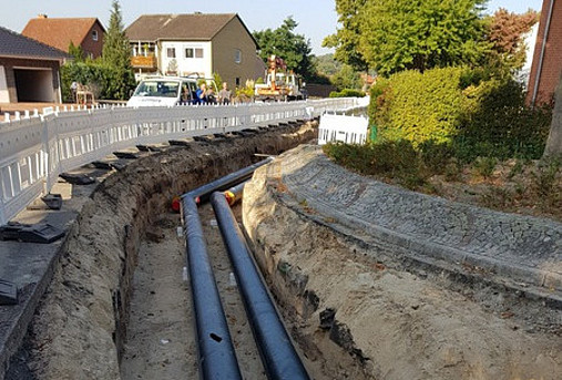 Zu sehen ist eine Baustelle mit einem Graben. Die ersten Rohre für ein neues Fernwärmenetz in der Gemeinde Flecken Steyerberg sind bereits verlegt.