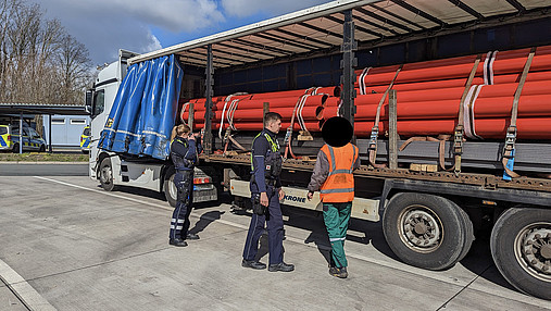 Foto zum Thema "Wie wird man Polizist*in": Zu sehen sind Svenja und ihr Kollege bei einer LKW-Kontrolle auf einem Autobahnparkplatz.