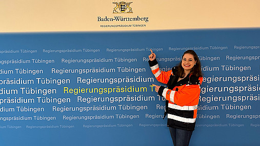 Foto zum Thema Public Management studieren: Zu sehen ist Julia, die das Studium absolviert hat und ihre Erfahrungen teilt. Sie eine trägt orangefarbige Sicherheitsjacke.