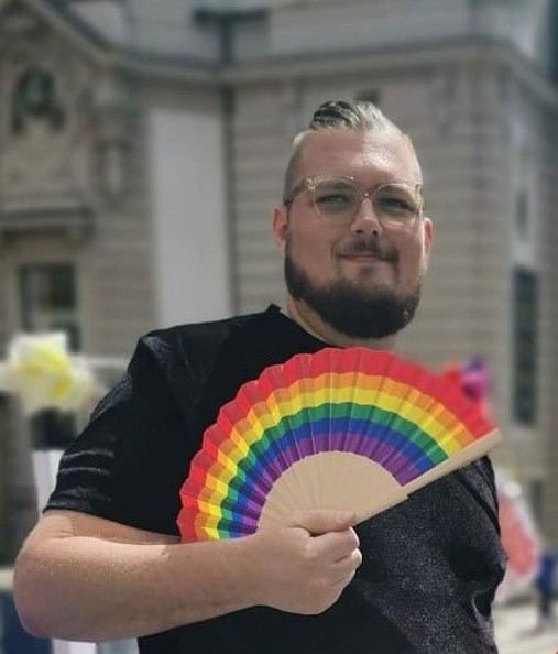 Foto zum Thema Coming-out am Arbeitsplatz: Zu sehen ist Henning Klemme von der AG Diversity der dbb jugend mit einem Regenbogen-Fächer in der Hand.