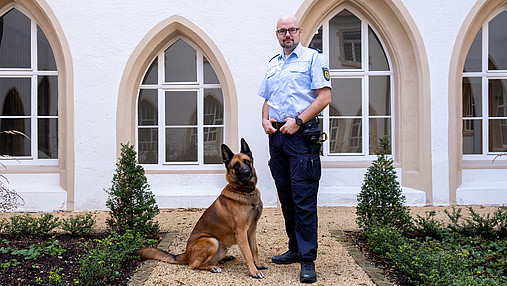 Foto zum Thema Ausbildung zum Justizvollzugsbeamten: Zu sehen ist Philipp, der seinen beruflichen Werdegang schildert, mit seinem Diensthund Balin.